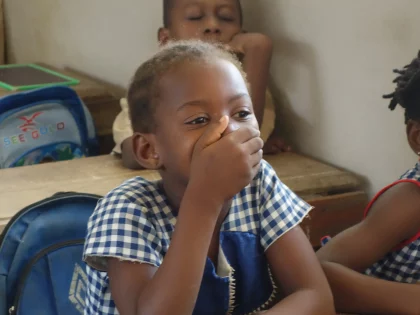 Child in class illustrating the educational objectives of Graines de Paix