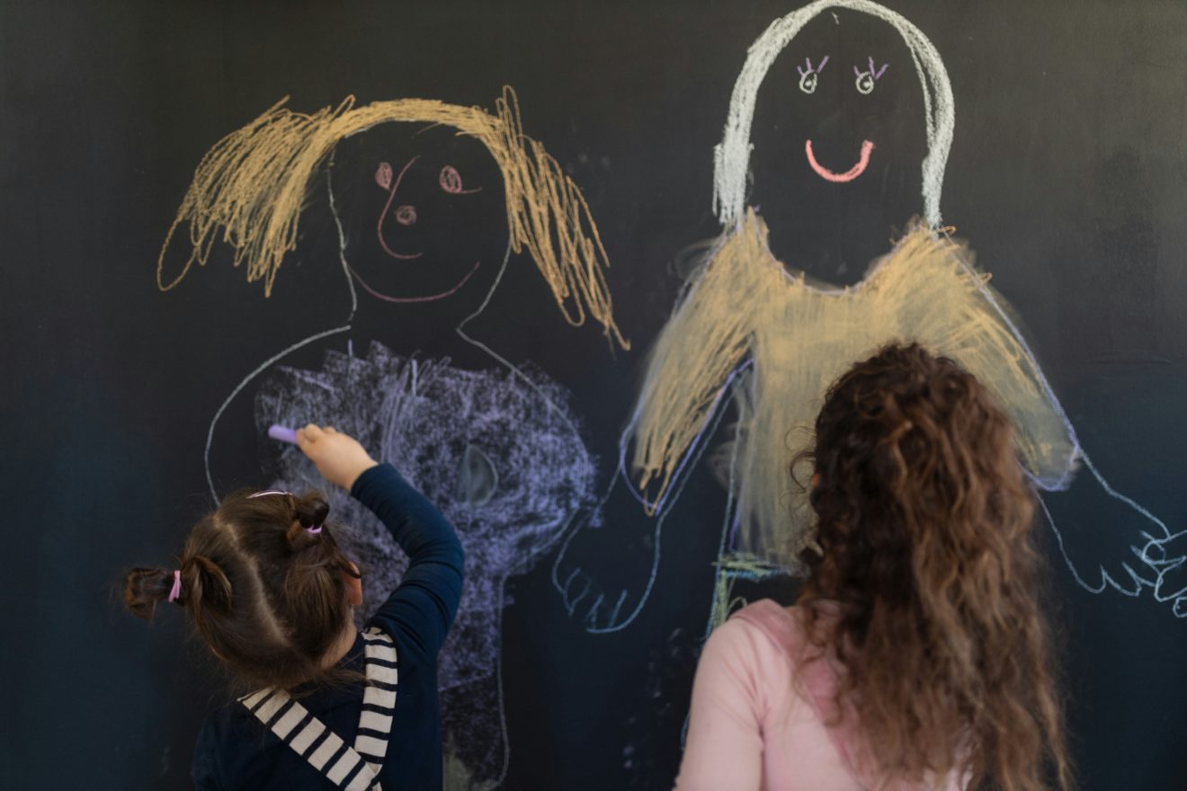 Two students drawing on a blackboard