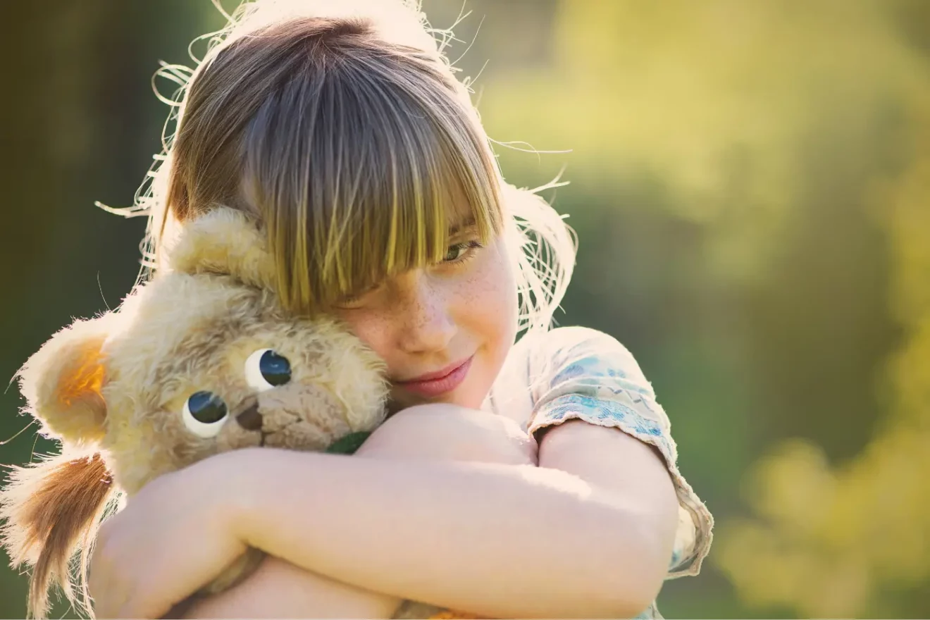 Little girl hugging a stuffed toy