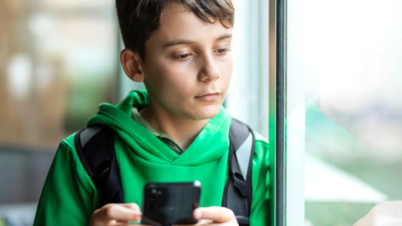 Adolescent avec un portable dans son école